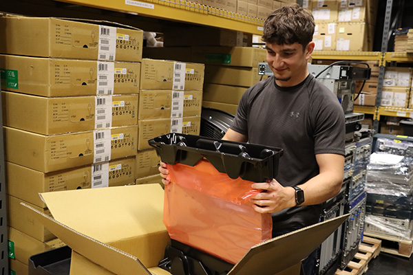 Asset Data Student Assistant Mitchell Kluchar handling equipment in OARnet's warehouse.