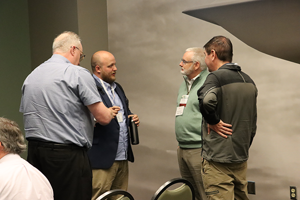 A group of individuals interacting at the 2023 Spring Member Meeting 