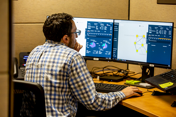 Person at two computer monitors