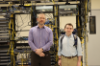 Doug Button (right) and Aaron Wise (left) standing in front of networking equipment.